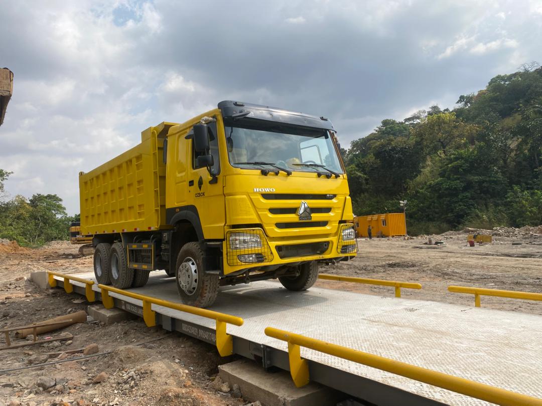 Yellow HOWO dump truck on a tested Kira Scales weighbridge platform